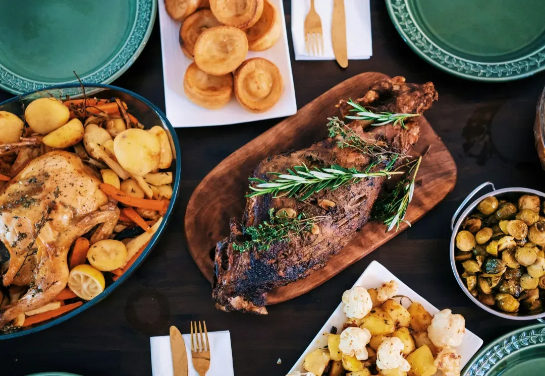 A family-style spread of roast meats, vegetables and sides, seen from above